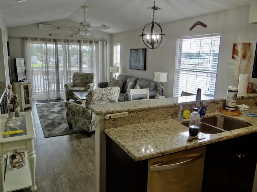 a kitchen with a sink and a living room at 26i WWV Myrtle Beach Intracoastal Waterway Gem in Myrtle Beach