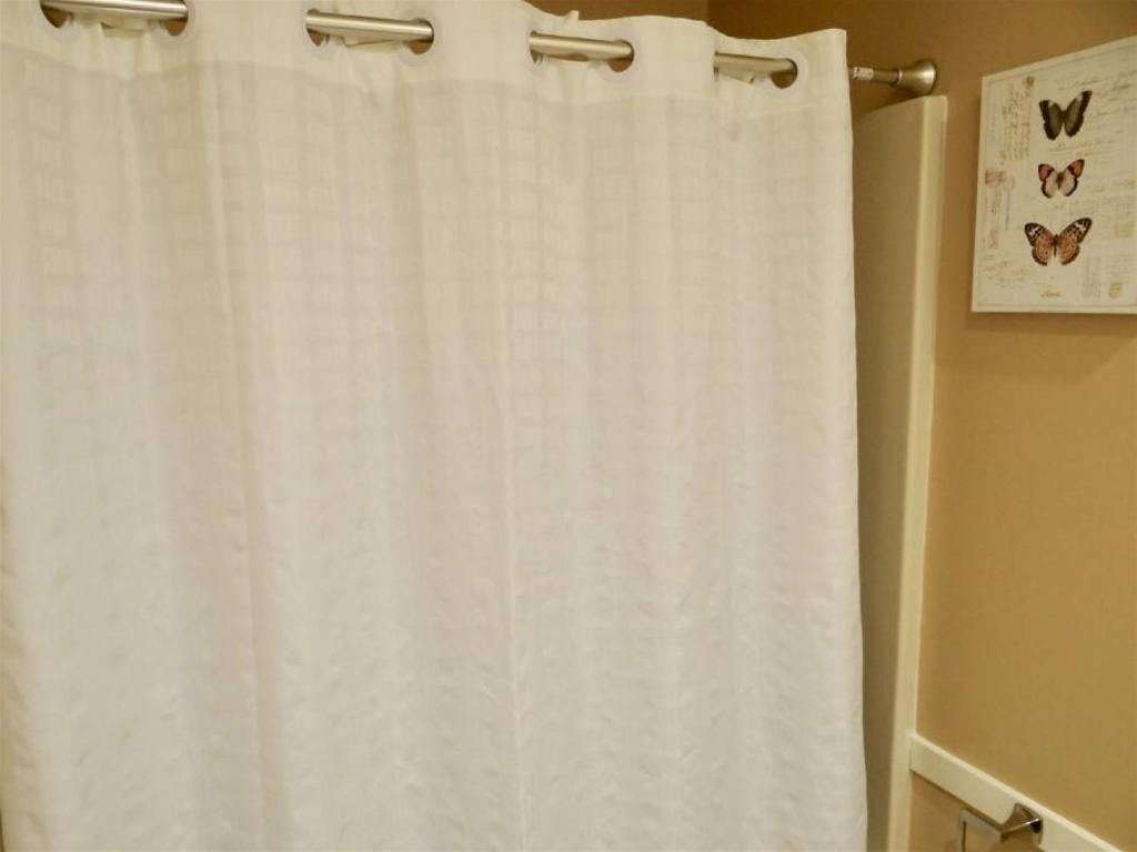 a white shower curtain hanging in a bathroom at Deerfield Plantation 217A2 in Myrtle Beach