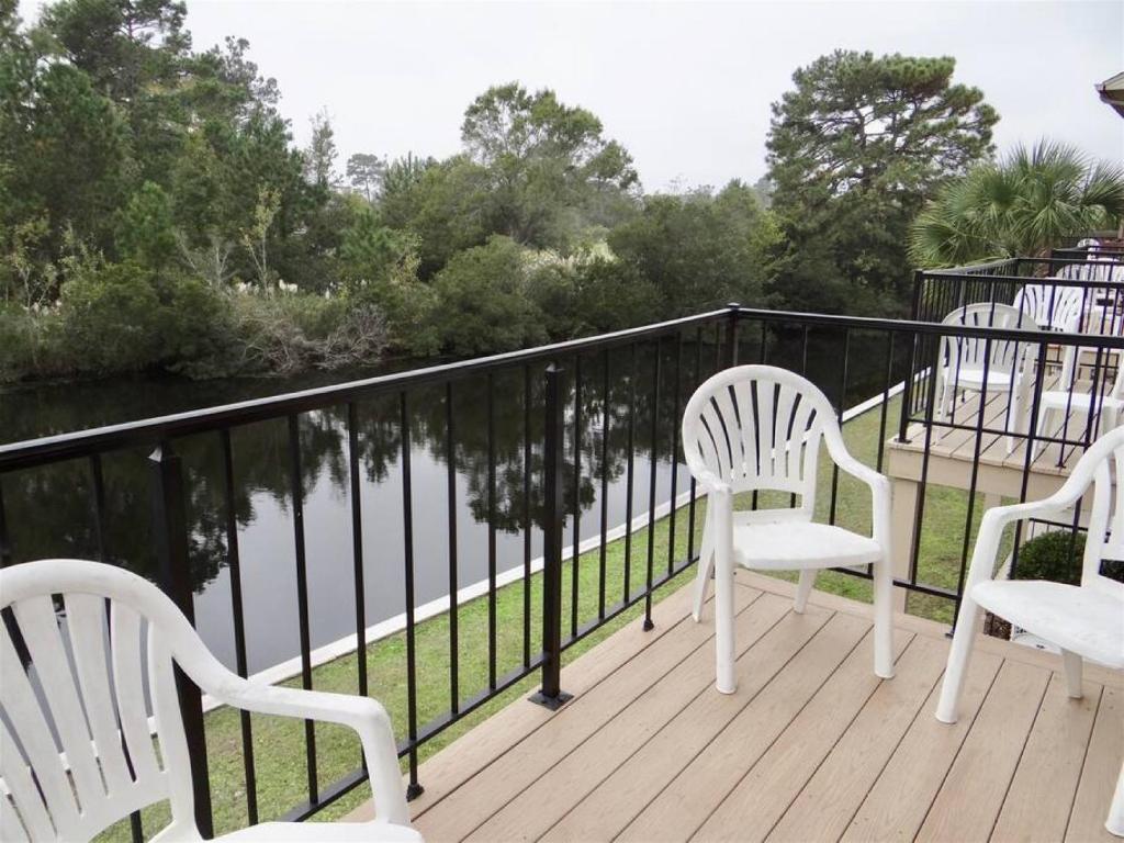 three white chairs sitting on a deck overlooking a river at Deerfield Plantation 217A2 in Myrtle Beach
