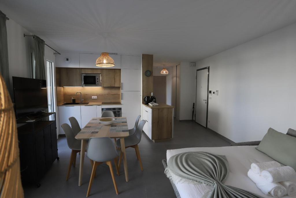 Ce petit appartement comprend une cuisine, une table et des chaises. dans l'établissement Reflet du Parmelan Annecy, à Annecy