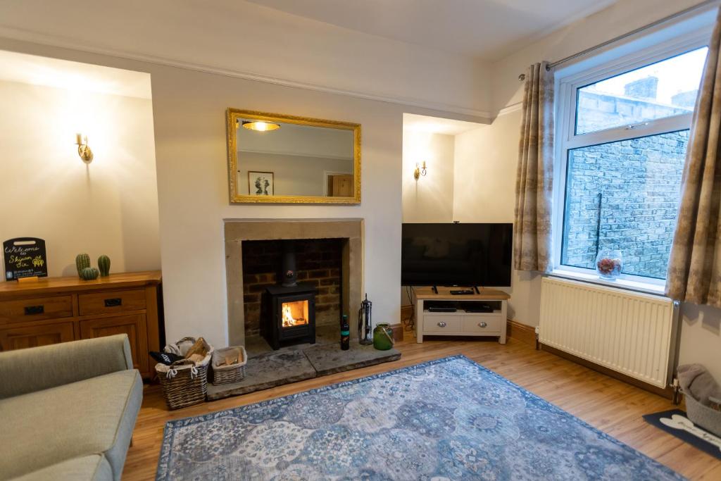a living room with a fireplace and a tv at Skipton at Six in Skipton