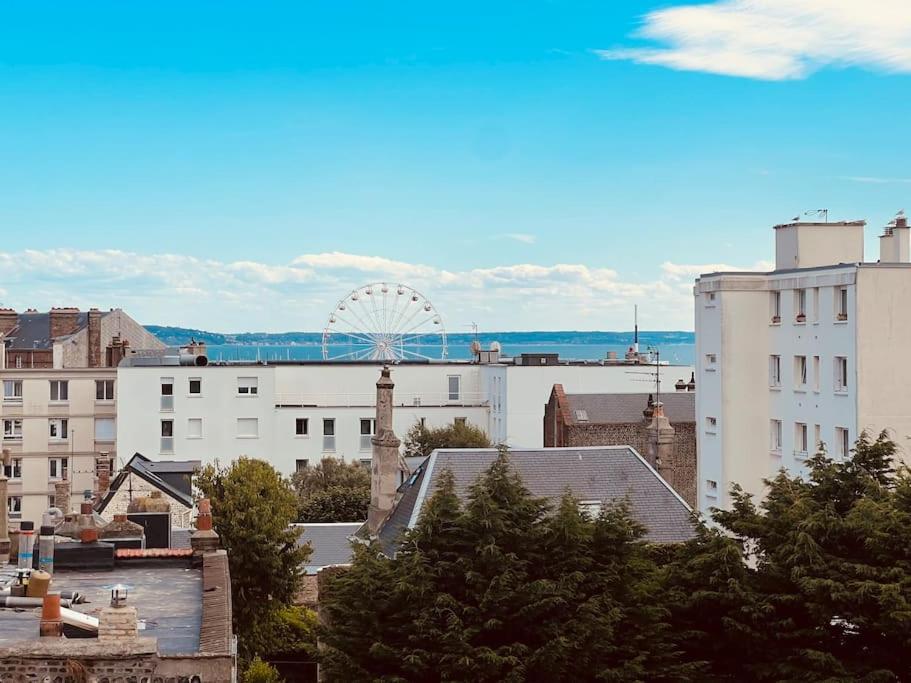 a city panorama with a ferris wheel in the distance w obiekcie Le petit nid perché sous les toits, vue mer w Hawrze