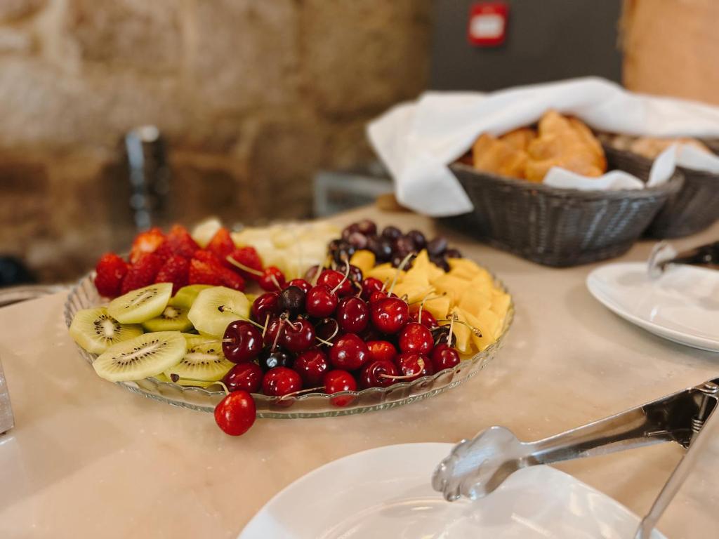 uma mesa com um prato de fruta sobre uma mesa em Casa das Muralhas na Covilh