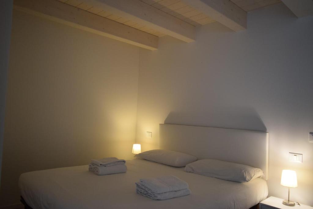 a bedroom with a white bed with two towels on it at Villa AMARE in Caorle