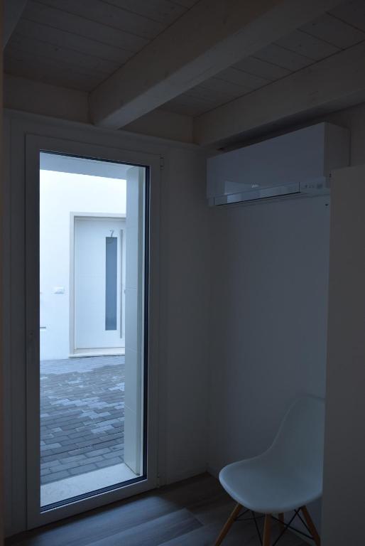 a white chair in a room with a window at Villa AMARE in Caorle