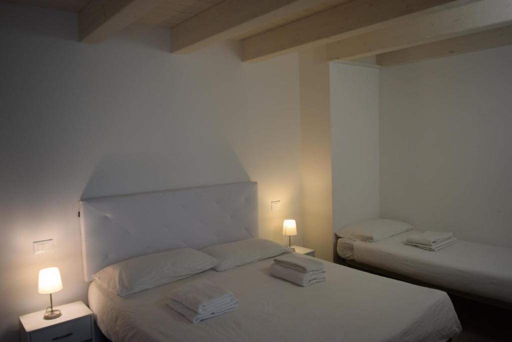 two beds in a room with two lamps on them at Villa AMARE in Caorle
