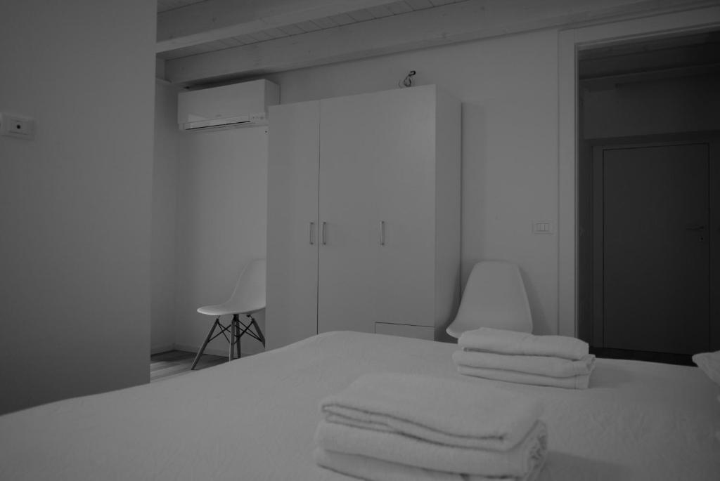 a white room with a bed with towels on it at Villa AMARE in Caorle