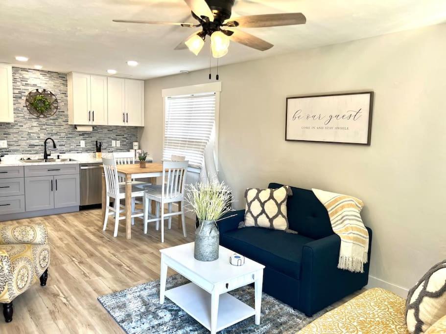 a living room with a blue couch and a kitchen at Guest Suites 1996 #2 - Fresh 1 bedroom 1 bath Suite in Idaho Falls