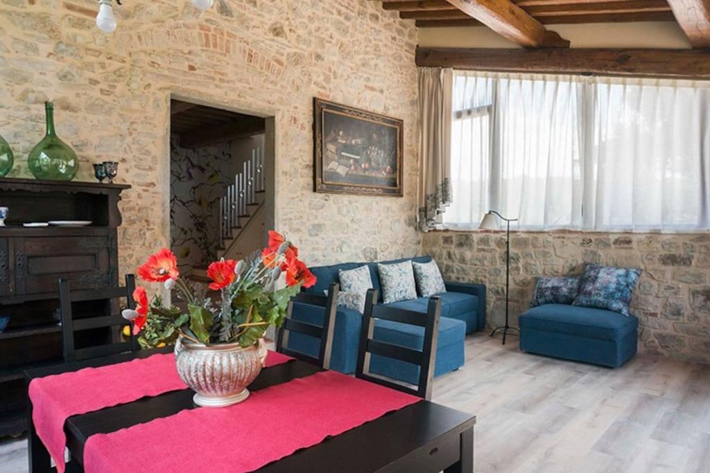 una sala de estar con un jarrón de flores sobre una mesa en FAETOLE typical Tuscan country house near FLORENCE, en Capannuccia