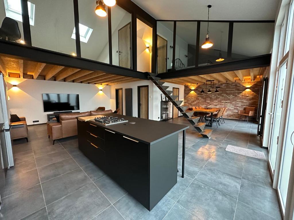 a kitchen and living room with a stove in a room at LFA Magnifique loft véritable avec sauna in Flémalle-Grande