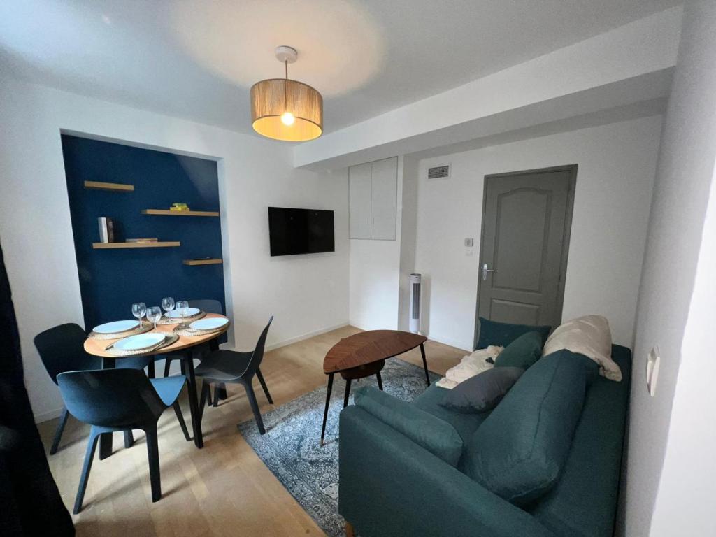 sala de estar con sofá verde y mesa en Le Rêve Bleu Appartement Hyper-centre en Carcassonne