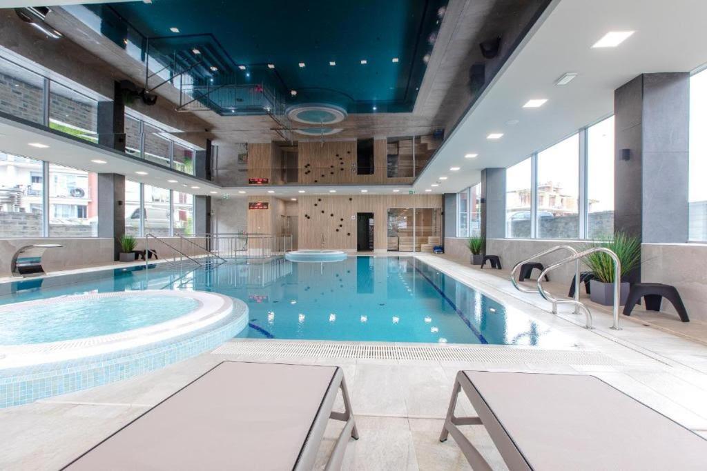 a large swimming pool in a building with windows at Apartament Faleza in Rewal