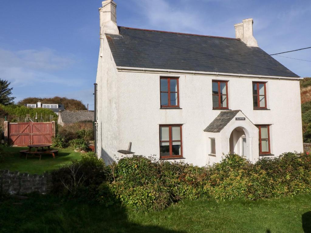 a white house with a black roof at Gladstone in Pwllheli