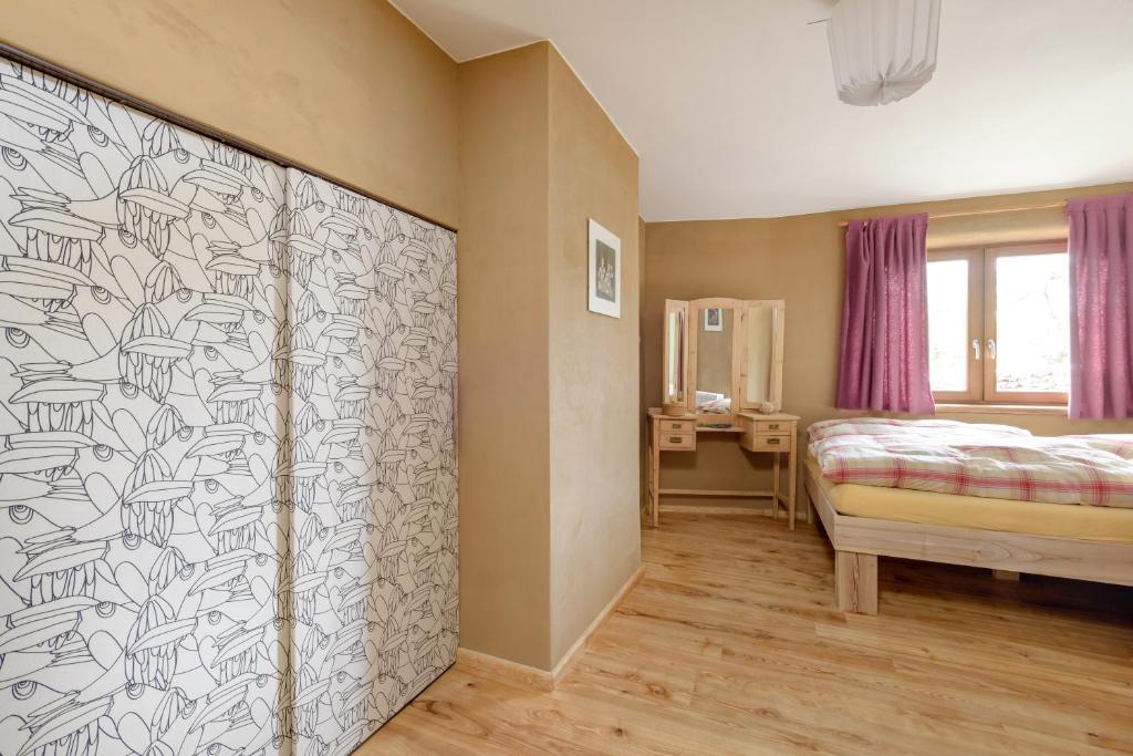 a bedroom with a bed and a wall at Kleine Ferienwohnung auf dem Land, Haus Hans Stepha in Gößweinstein