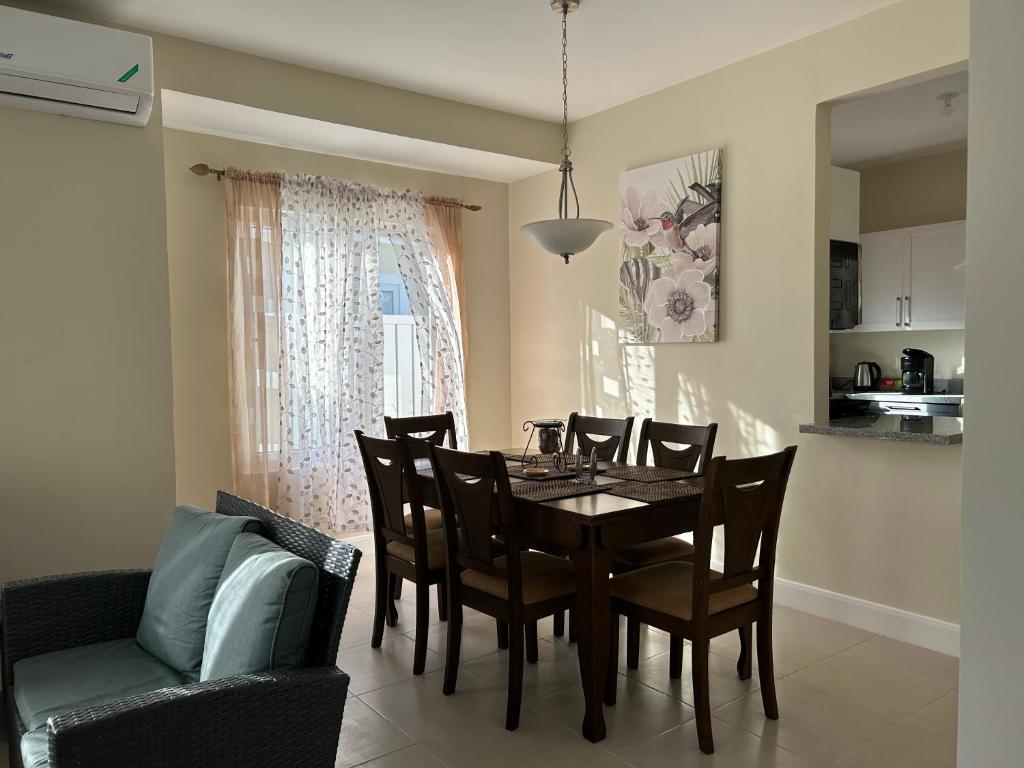 a dining room with a table and chairs at Seamist villa @Oceanpointe Lucea comfy 2BR w/pool gym & parking in Lucea