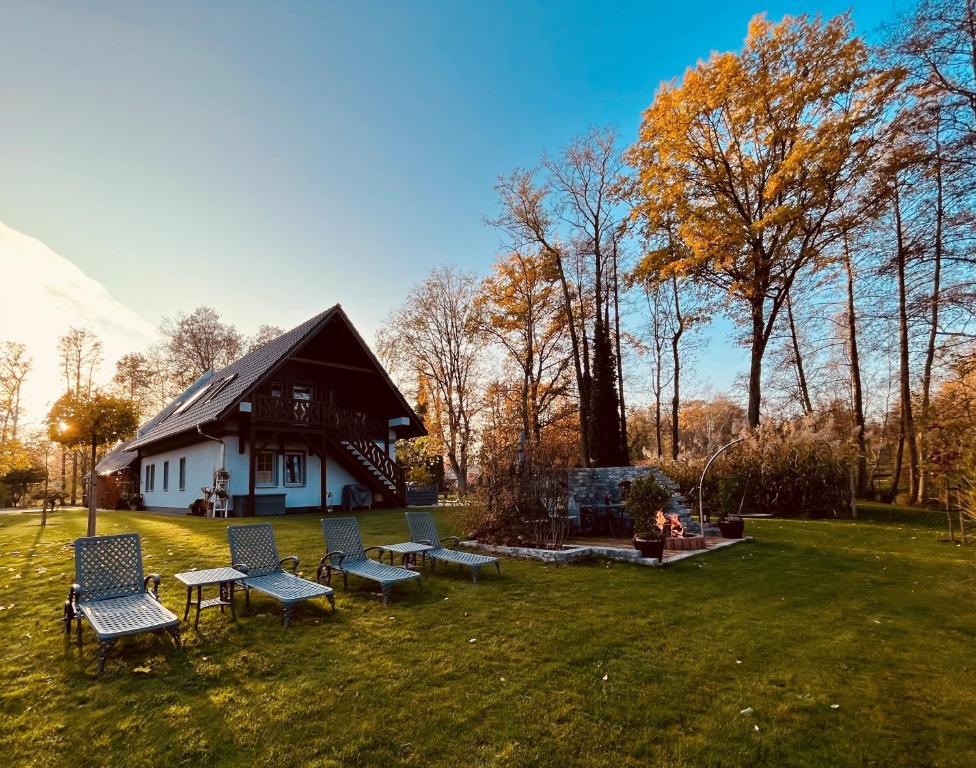 a group of chairs sitting in the grass in front of a house at Ferienwohnungen Ast in Burg