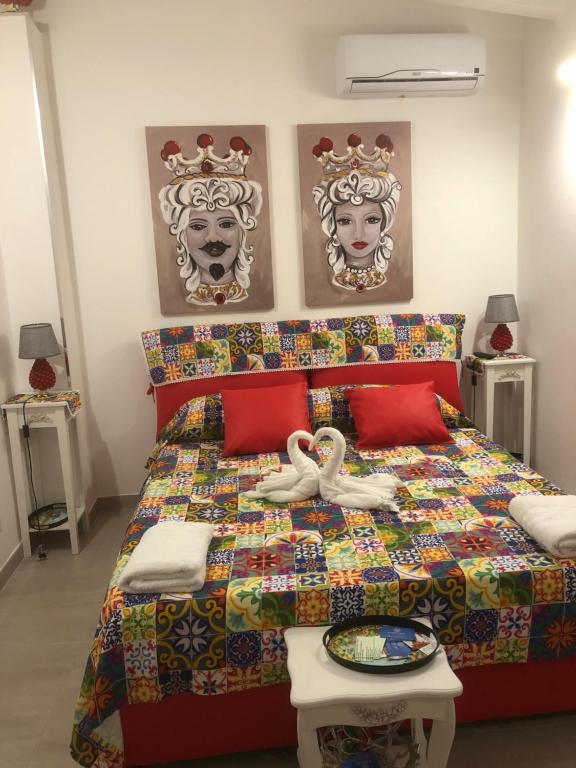 1 dormitorio con 1 cama con edredón colorido y 2 máscaras en MARINA BAY, en Terrasini