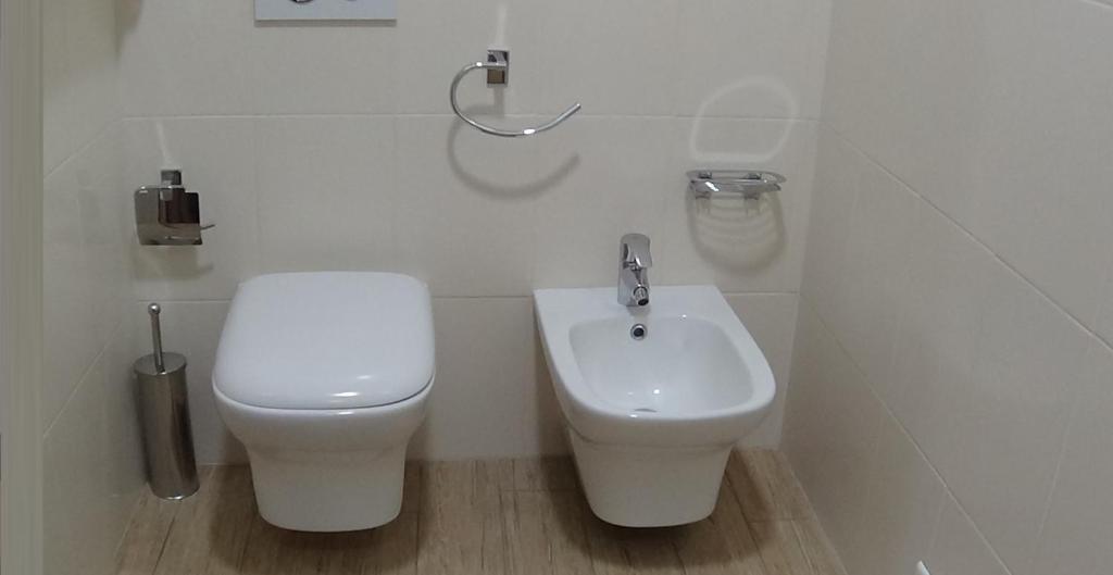 un bagno bianco con un water e un lavandino di Residence SANTABBONDIO a Como