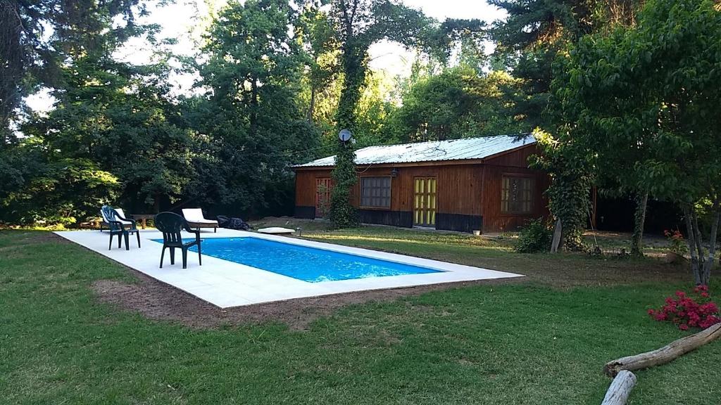 a pool with a table and chairs in a yard at Entrepinos Mendoza in Ciudad Lujan de Cuyo