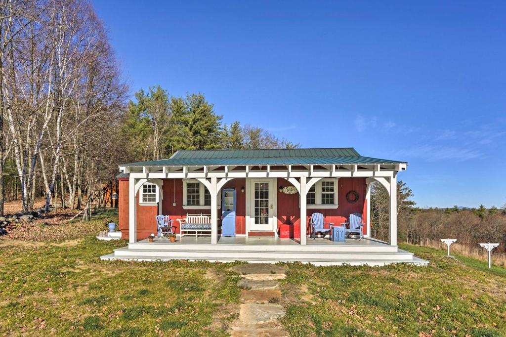 una pequeña casa roja con cenador en Cozy Fiddlers Rest Cabin 11 Miles to Skiing!, en Bernardston