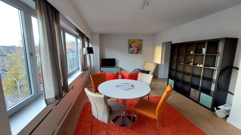 uma sala de estar com uma mesa e um sofá em Astrid - apartments em Mechelen