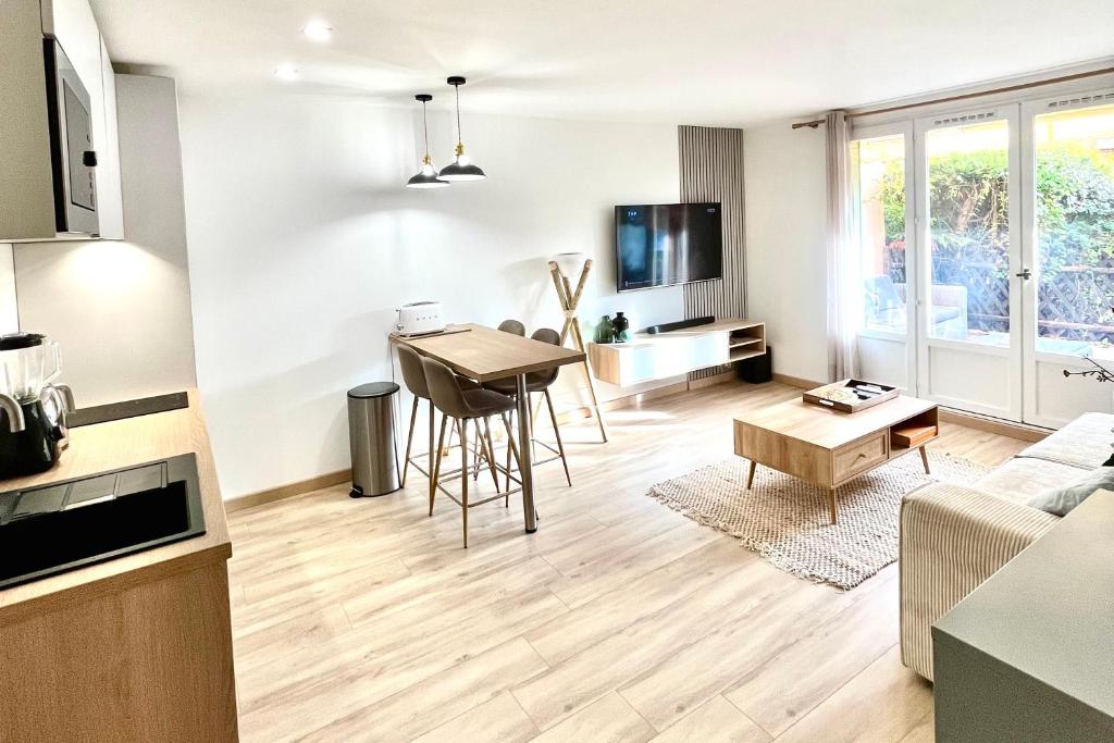 une cuisine et un salon avec une table et un canapé dans l'établissement Magnifique 2 Chambres Terrasse et Parking, à Saint-Tropez