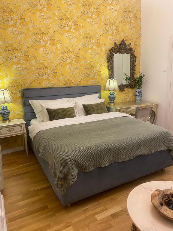 1 dormitorio con 1 cama grande y pared amarilla en NaNa Flat, en Praga