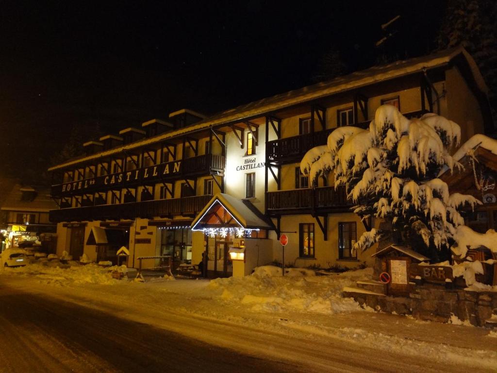 a large building with snow on it at night at Hotel Castillan in La Grave