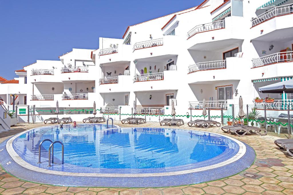 a swimming pool in front of a building at Gorgeous Los Diamantes Home by LoveTenerife in Los Cristianos