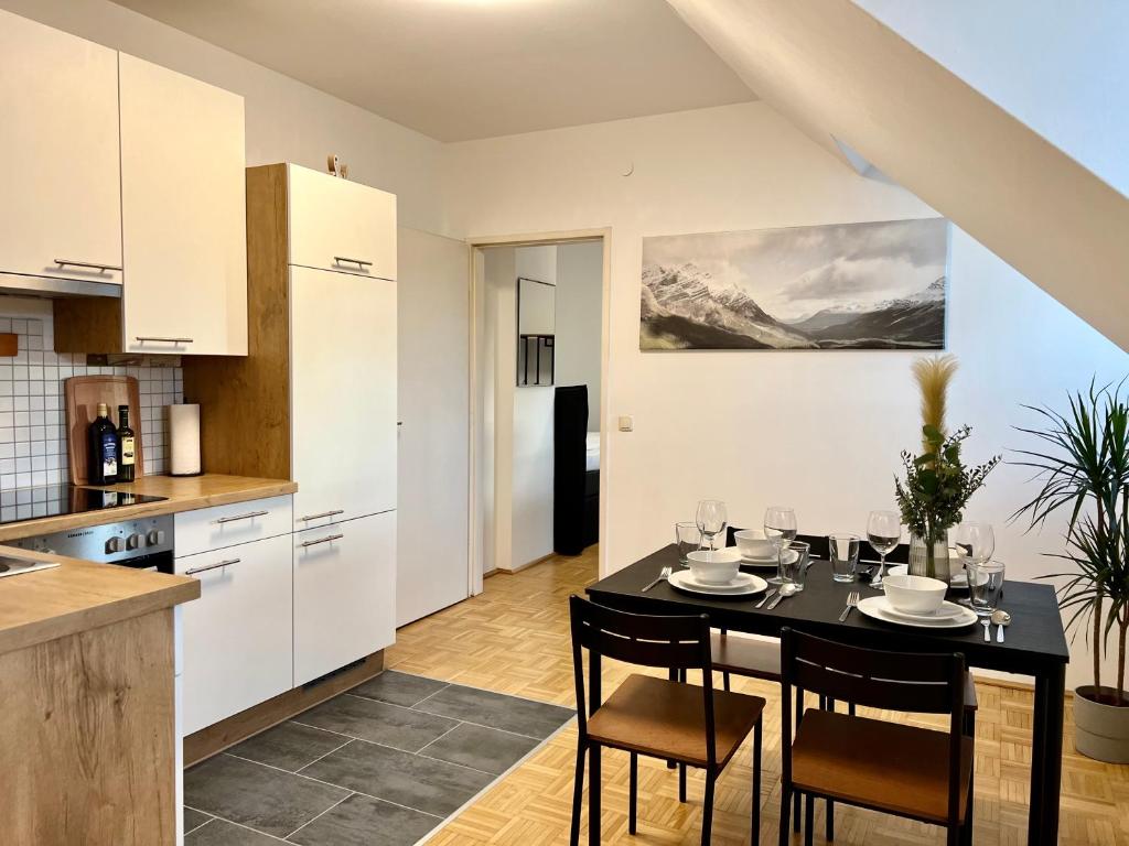 a kitchen with a table and chairs in a room at urbanstays Linz Landstraße - city center - near casino in Linz