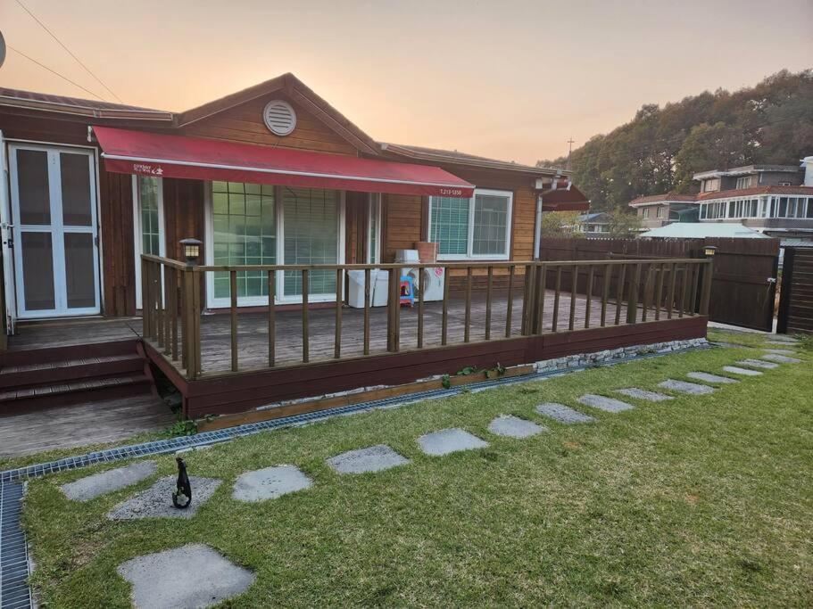 a house with a wooden deck and a yard at Hongcheon fence house in Hongcheon