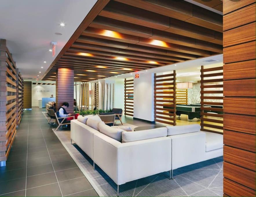 a lobby with a white couch and people sitting in chairs at Stunning condo wit amazing view 5mins from cntower in Toronto