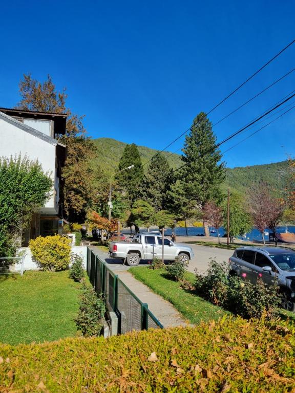 a street with cars parked next to a house at Puerto Lacar Lodge SMARG in San Martín de los Andes