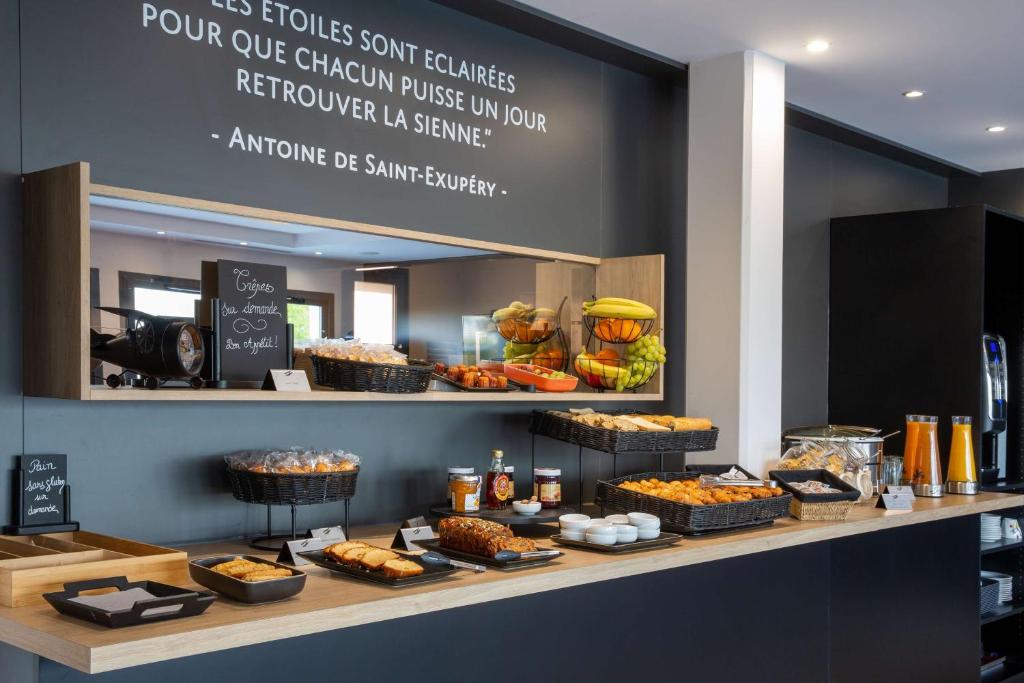 eine Bäckerei mit verschiedenen Backwaren und anderen Lebensmitteln in der Unterkunft Best Western St Exupery Bordeaux Ouest in Eysines