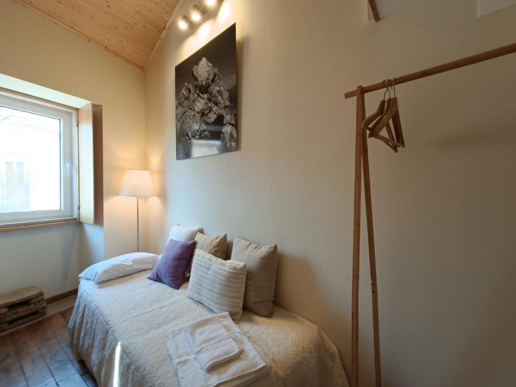 una camera con un letto in una stanza con una finestra di Casa CÔA - Casas de Villar - Rural Experience a Vilar de Amargo
