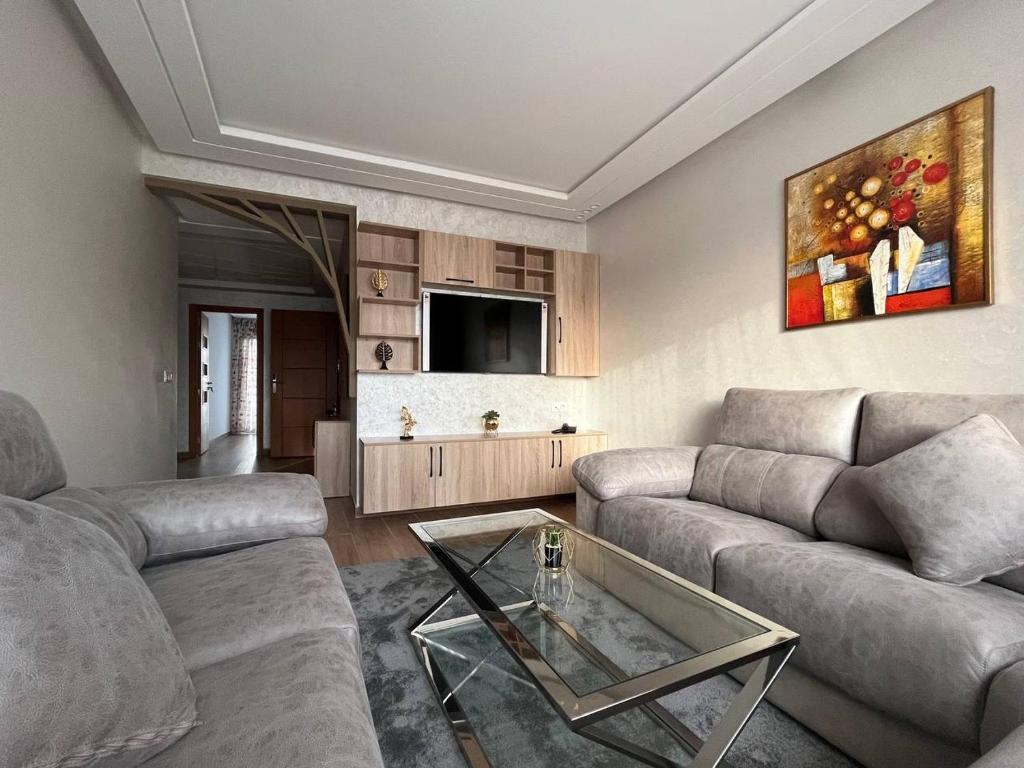 - un salon avec deux canapés et une table en verre dans l'établissement Welcome house appart'hôtel, à Tanger