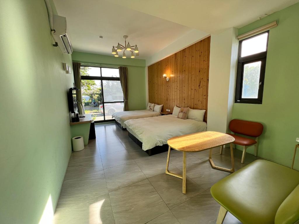 a bedroom with two beds and a table and a couch at Kenting Peninsula Inn in Kenting