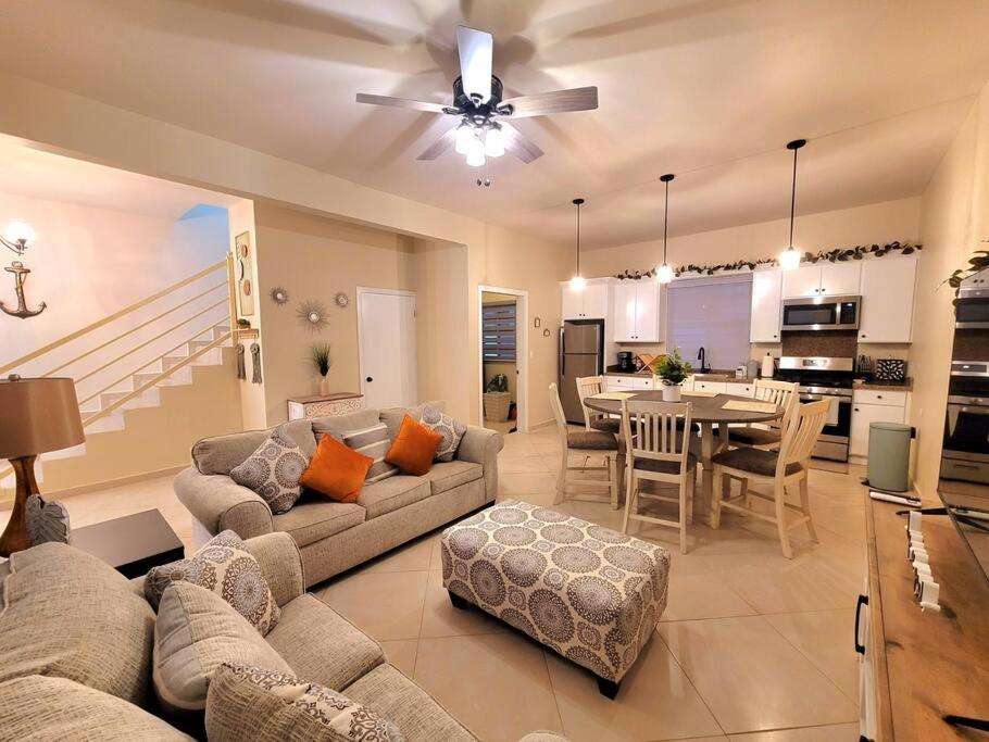 Earthy 2 Story Beach House! في بورتو بيناسكو: غرفة معيشة مع أريكة وغرفة طعام