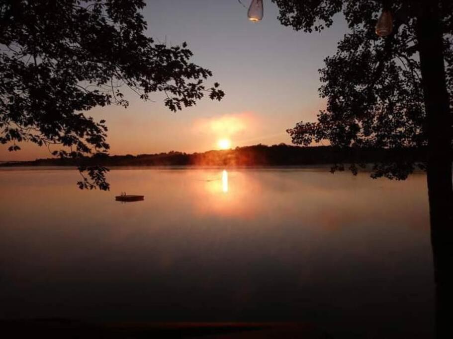 un coucher de soleil sur un lac avec un bateau sur l'eau dans l'établissement Sunrise Views Cabin with King Bed, Bar & Game Room, 