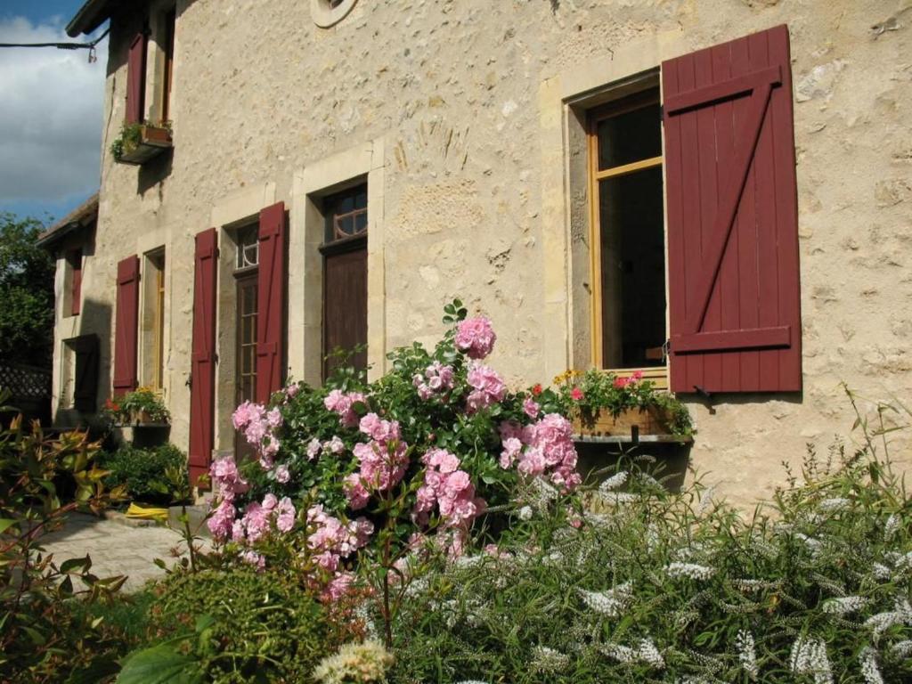 una finestra con persiane rosse e fiori di fronte a un edificio di Maison du XVe restaurée avec cheminée, jardin clos et bar privé - FR-1-410-127 a Crannes-en-Champagne