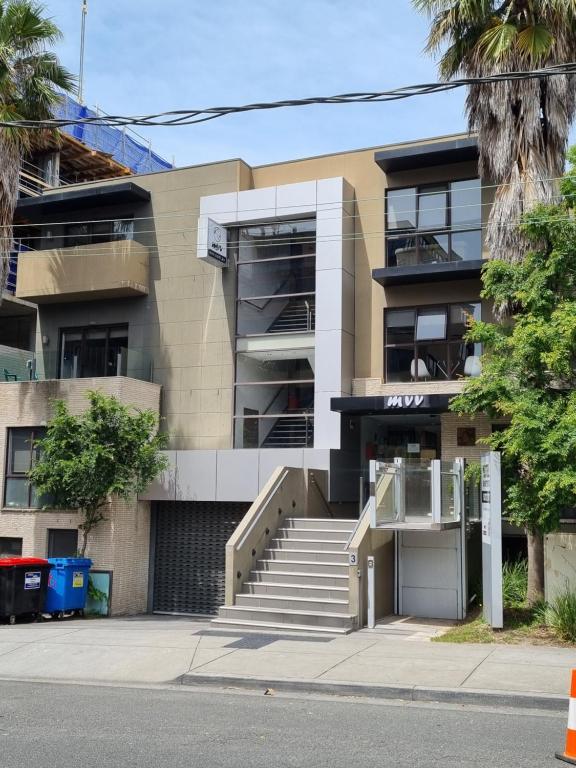 an apartment building with stairs in front of it at Melbourne ViVo in Melbourne