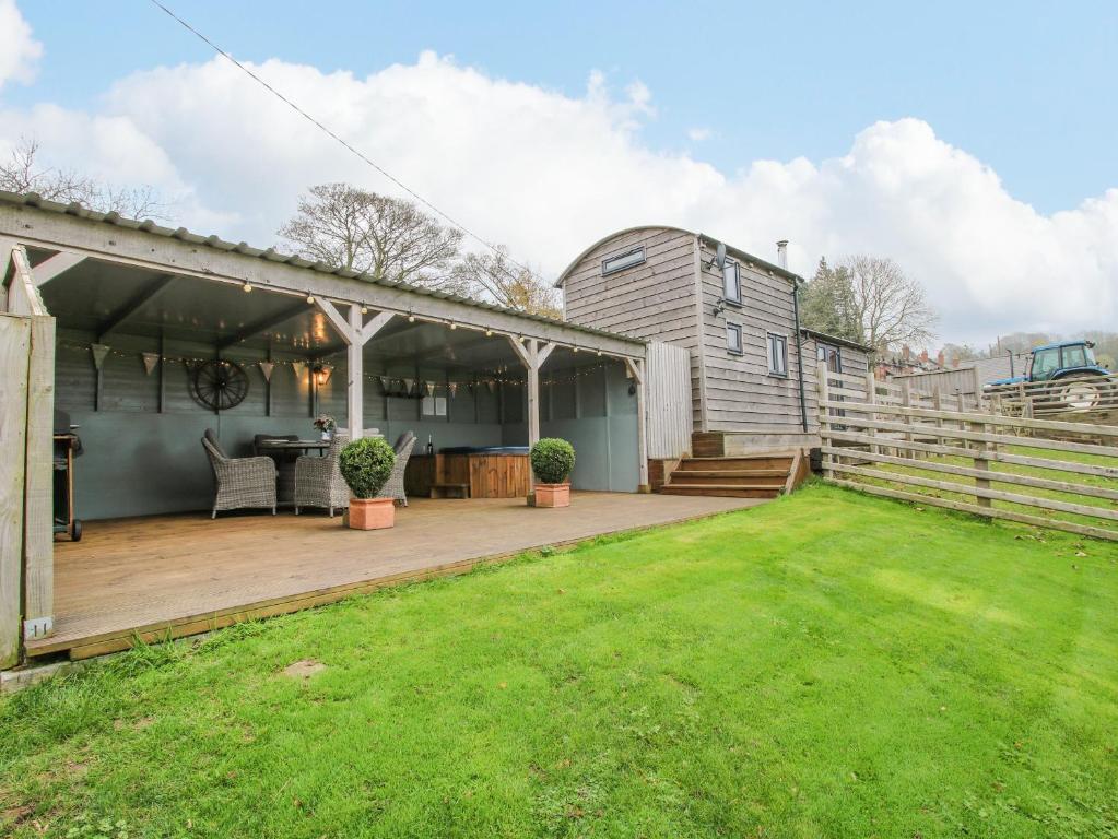 a backyard with a wooden deck and a house at Shepherds Cabin at Titterstone Hot Tub & Dog-Friendly near Ludlow in Farden