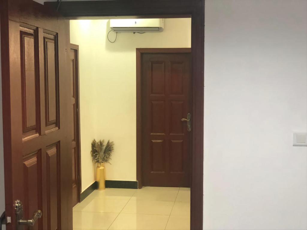 un corridoio con una porta e una pianta in vaso di Suite Grace a Libreville