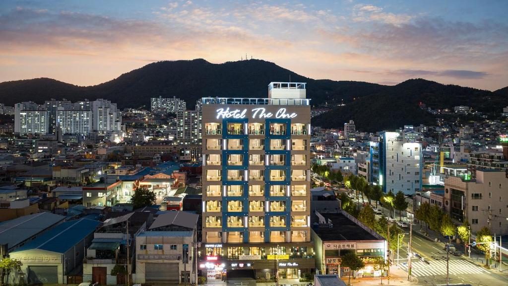 a tall building with a sign on it in a city at Hotel The One in Yeosu