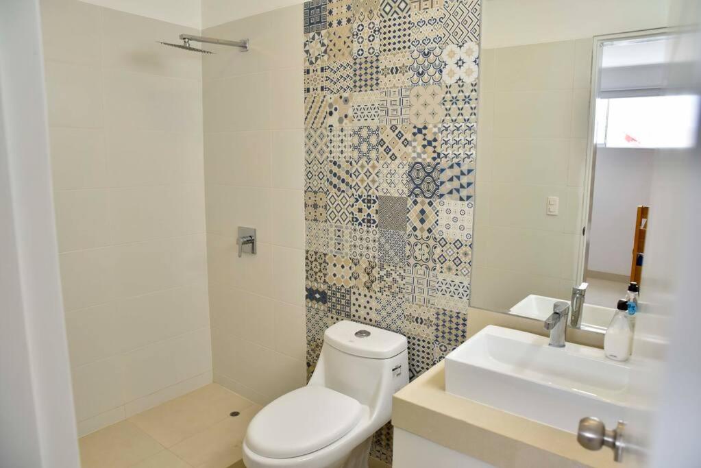 a bathroom with a toilet and a sink at Casa de playa: Disfruta de grandes momentos y del sol todo el año en Paracas in Paracas