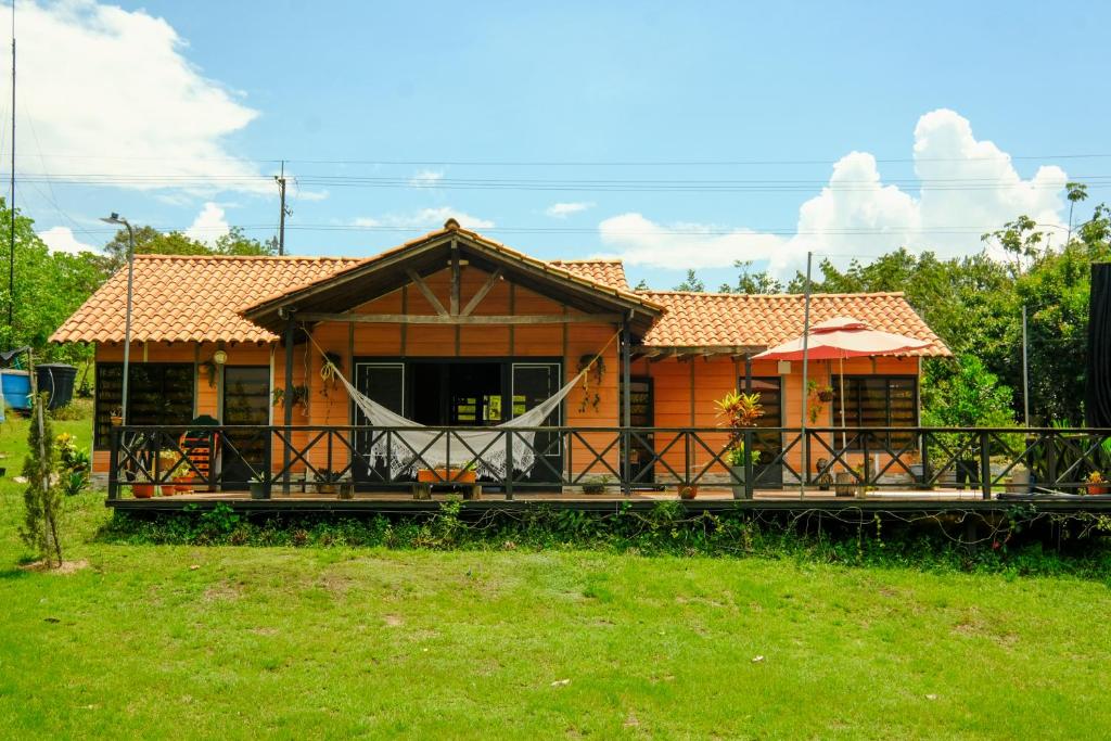 a large wooden house with a large deck at Cabañas El Morichal in San José del Guaviare