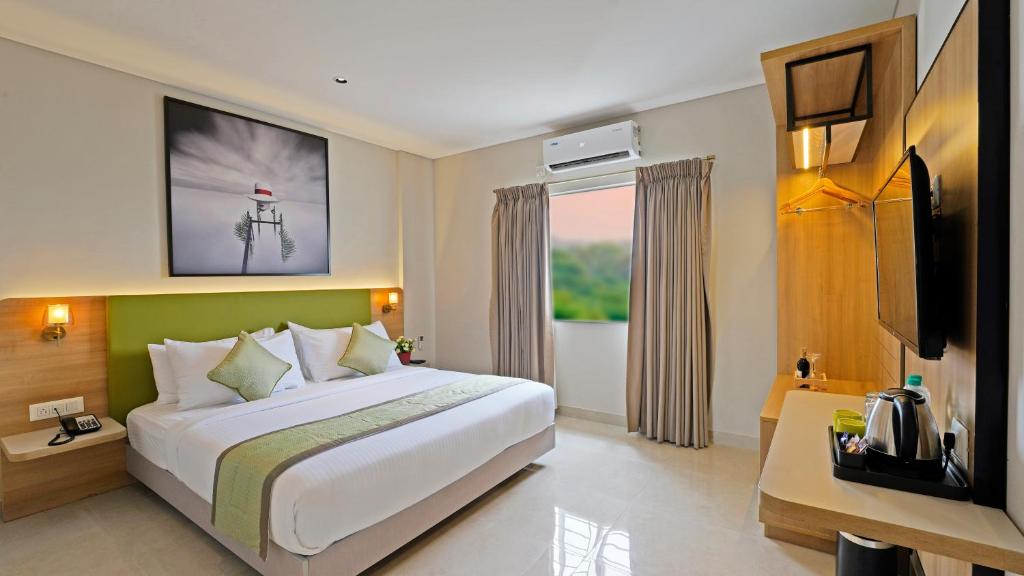 Cette chambre comprend un grand lit et une télévision. dans l'établissement Click Hotel Biz, Bangalore International Airport, à Yelahanka
