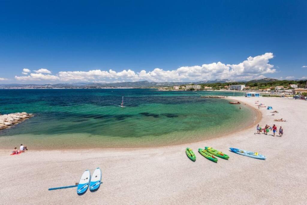 a beach with a group of people and boats on it at Maison T2 proche mer jardin et parking securise in Six-Fours-les-Plages