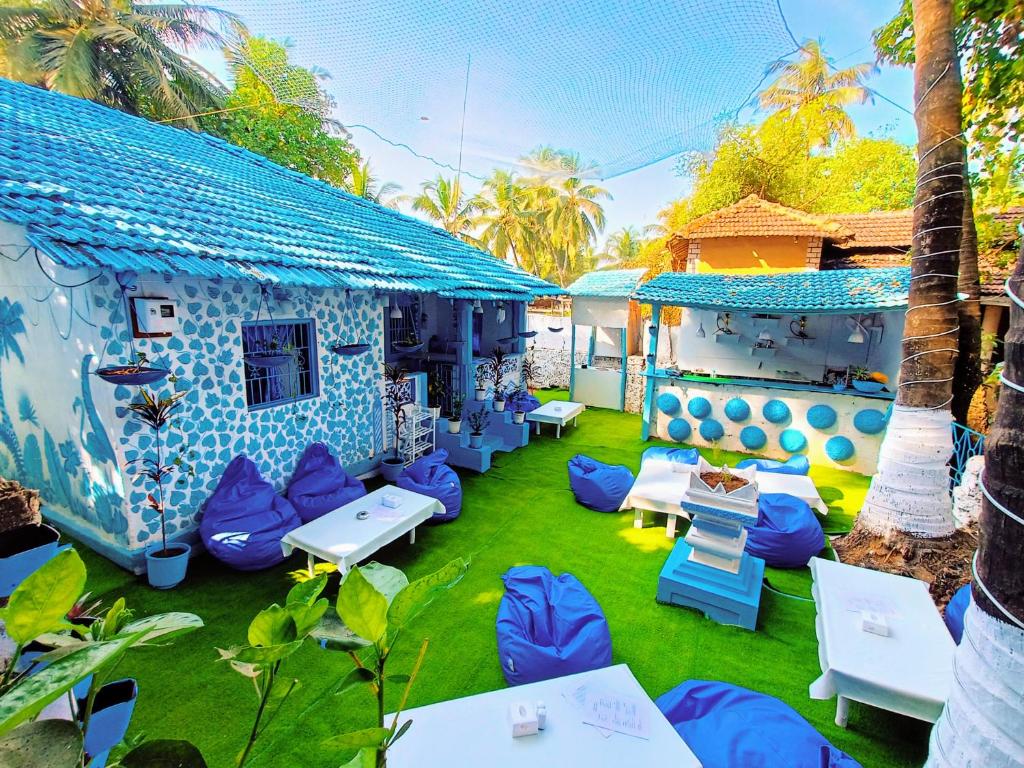 un patio con sillas azules y blancas y una casa en Omkar wellness inn en Arambol