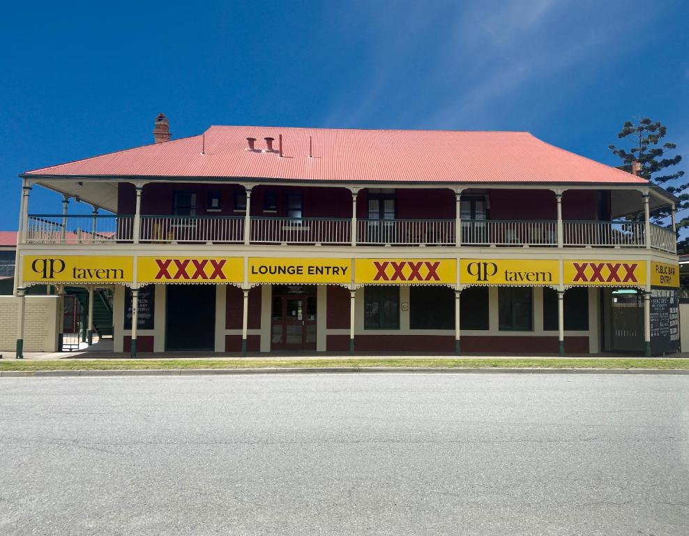 a yellow and red building with a red roof at Queensport Tavern And Motel in Brisbane